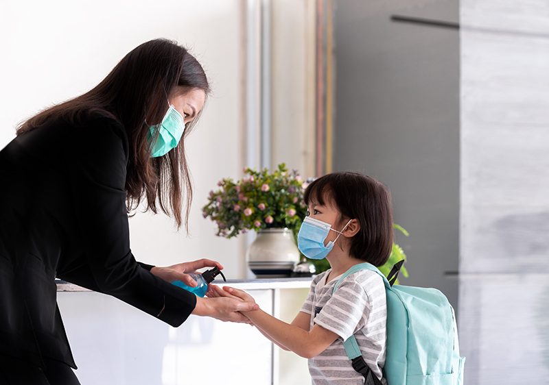 mother putting hand sanitizer on child